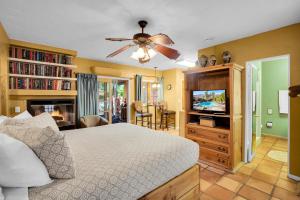 a bedroom with a bed and a flat screen tv at Coyote Inn - 21 and Over in Palm Springs