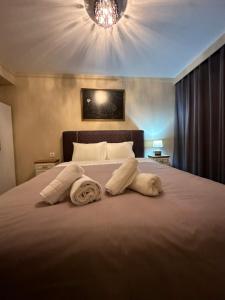a bedroom with a large bed with towels on it at Modis Apartment in Volos