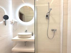 a bathroom with a sink and a shower with a mirror at Annie Villa in Siófok