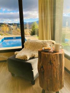 ein Raum mit einem Stuhl und einem Tisch und einem Fenster in der Unterkunft Casa Patagonia in San Martín de los Andes
