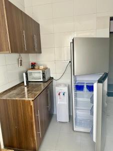 uma cozinha com geladeira e micro-ondas em 3-Bedroom Duplex Apt em Dar es Salaam