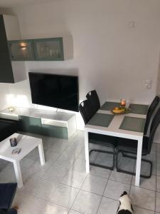 een tafel en stoelen in een woonkamer met een hond bij ruhig aber zentral gelegene Ferienwohnung im Erdgeschoß in Dornum