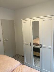 een slaapkamer met een witte kast en een bed bij ruhig aber zentral gelegene Ferienwohnung im Erdgeschoß in Dornum +5 foto's