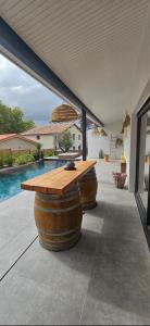 a patio with a wooden table and two wine barrels at Loft & spa d'Autan in Villefranche-de-Lauragais