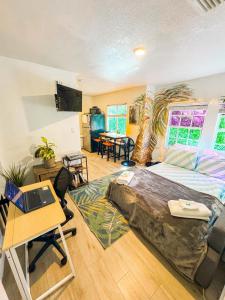迈阿密Quiet & Centrally located House - PRIVATE PARKING, LAUNDRY AND STORAGE FOR LUGGAGE的一间卧室配有一张床和一张带笔记本电脑的书桌 更多37张照片