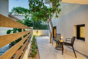a patio with two chairs and a tree in a building at Virginia Haven in Chios