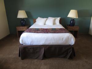 een slaapkamer met een groot bed en 2 slaapstandbedden met elk een eigen badkamer. bij Al's Westward Ho Motel in West Yellowstone
