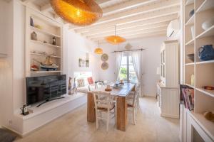 a dining room with a table and a fireplace at Manu Mykonos Exclusive Villa Luxury Beachside Stay with Private Pool by Quality Brand Villas in Kalafatis