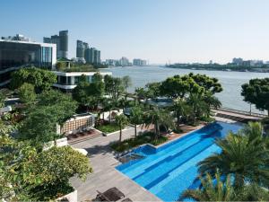 a swimming pool with a view of the water and buildings at White Swan Hotel in Guangzhou