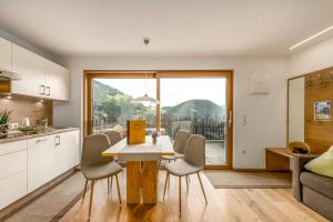 a kitchen and dining room with a table and chairs at Tratterhof Apartments in Vallarga +46 photos