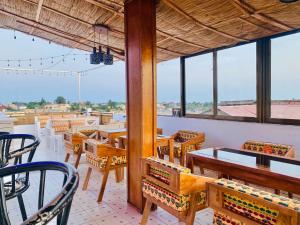 a restaurant with tables and chairs and windows at GRACE LODGE in Lomé