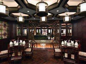 a dining room with tables and chairs and chandeliers at White Swan Hotel in Guangzhou