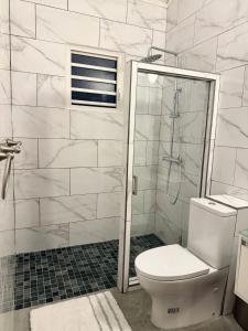 a white bathroom with a toilet and a shower at Beach Retreat on Front Street in Philipsburg