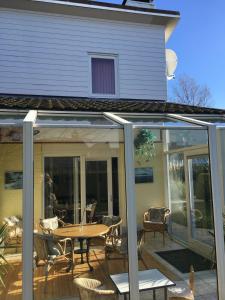 an open patio with a table and chairs on a deck at freistehendes Ferienhaus mit Sauna und Kamin in Kamperland +21 photos