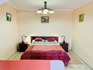 Un dormitorio con una cama con dos mesitas de noche y dos lámparas. en Savelij apartament, en Hévíz