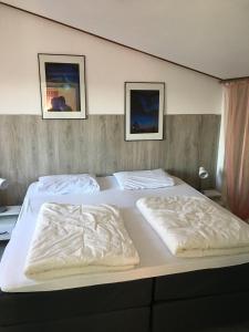 a bedroom with two beds with white blankets on them at freistehendes Ferienhaus mit Sauna und Kamin in Kamperland