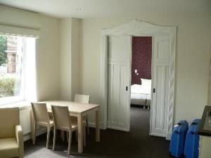 a dining room with a table and chairs and a bedroom at Apartment Im Hotel Insel Pension In Niebüll in Niebüll