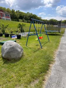 a playground with a rock and a swing at Fornaci Lodge - Rosso in Sospirolo