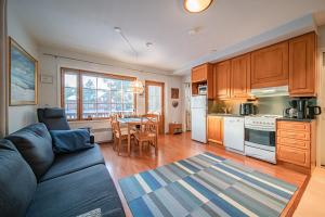 a living room with a couch and a kitchen with a table at Levinalppi 2 App 8 in Kittilä