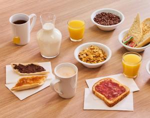 a table with breakfast foods and drinks on it at Premiere Classe Troyes Sud - Parc St Thibault - Buchères in Troyes