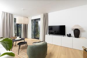 a white living room with a tv and a couch at Villa Vartal in Ivan Dolac