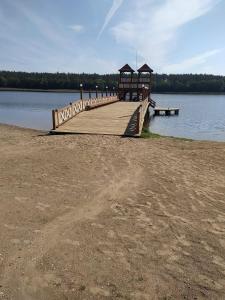 a wooden dock with a gazebo on a lake at Mieszkanie do wynajęcia w Centrum in Olecko