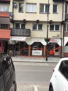 a building with an orange ribbon in front of a street at Mieszkanie do wynajęcia w Centrum in Olecko