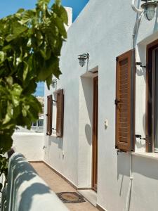 a white building with brown doors and windows at Home Sweet Home Milos in Triovasálos