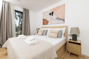 Un dormitorio con una cama con sábanas blancas y una ventana. en Villa Vartal, en Ivan Dolac 79 fotos más