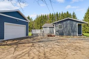 a house with a garage and a driveway at Less Than 3 Mi to Double JJ Resort Home with Large Yard! in Rothbury