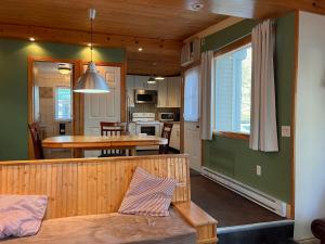 Una cocina y una sala con una mesa y un comedor. en Camping Chalets Lac St-Augustin, en Quebec