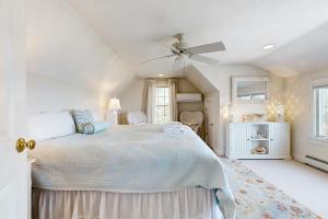 une chambre blanche avec un lit et un ventilateur de plafond dans l'établissement Ocean House, à Nameloc Heights