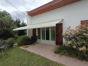 a white house with awning and a patio at Logement entier in Nemours