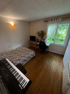a bedroom with a bed and a desk and a window at Logement entier in Nemours