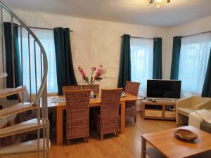 sala de estar con mesa con sillas y TV en Ferienwohnung Daun, en Daun