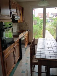 a kitchen with a table and a dining room at Logement entier in Nemours +16 photos