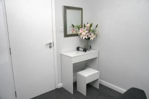 a bathroom with a toilet and a mirror and flowers at Telford - Apartment - Sleeps 5 - Flat 4 in Telford +5 photos