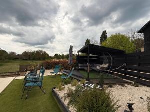 a group of chairs sitting on the grass in a yard at Charme rustique- piscine privée et jardin in Queyssac