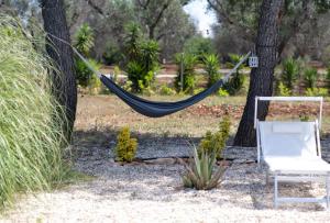 a hammock and a chair in a garden at Villa Myricae by Bianco Puglia Vacanze in San Vito dei Normanni