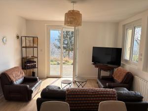 a living room with couches and a flat screen tv at La Terrasse du Serre in Plan-de-Vitrolles