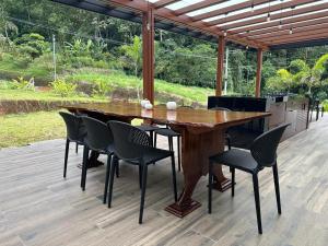 a wooden table and chairs on a patio at Casa de la Cascada in Pedro Vicente Maldonado