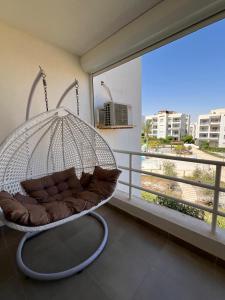 a swinging bed in a room with a balcony at Amwaji in El Alamein