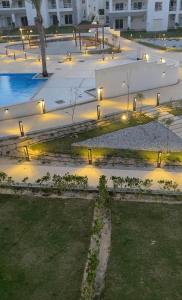 a courtyard with benches and lights at night at Amwaji in El Alamein +10 photos