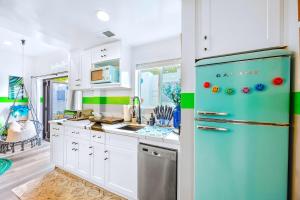 a kitchen with white cabinets and a blue refrigerator at D- Hip NoHo Haven Hot Tub - Family - Parking in North Hollywood