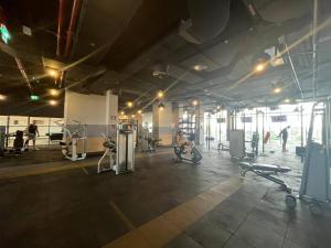 a gym with people exercising in a large room at Damac Hills 2 Villa Pool Front + Waterpark Access in ‘Ūd al Bayḑāʼ