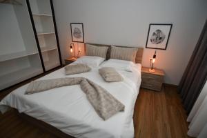 a bedroom with a large white bed with two pillows at Black and white suites 2 in Thessaloniki
