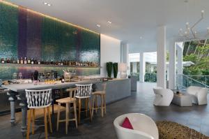 a kitchen with a bar with stools and chairs at The Nai Harn in Nai Harn Beach