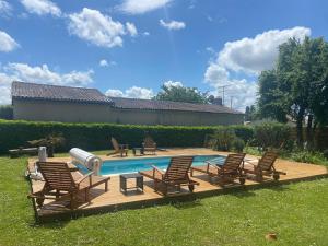 a group of chairs sitting next to a swimming pool at L Atelier Demoiselle in Cadillac