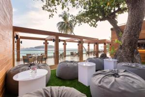 a patio with gray bean bags and tables and a tree at The Nai Harn in Nai Harn Beach