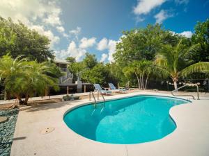 a swimming pool in a yard with palm trees at Casa de Sueno in Summerland Key